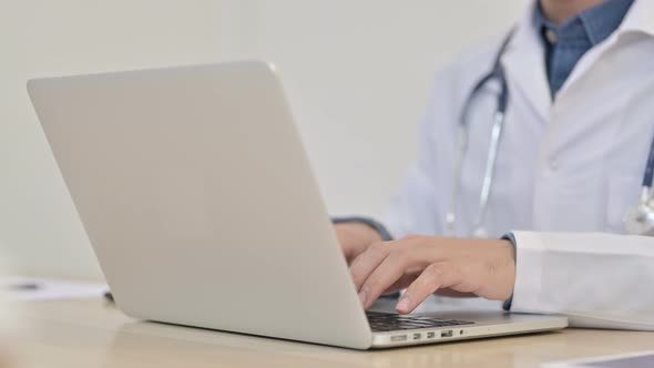 Close Up of Male Doctor Typing on Laptop 