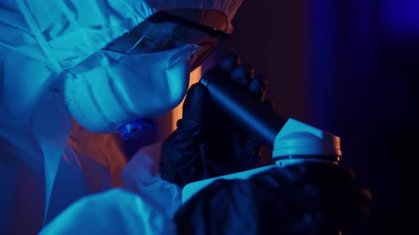 A Woman Scientist is Looking Into Microscope Biochemical Research