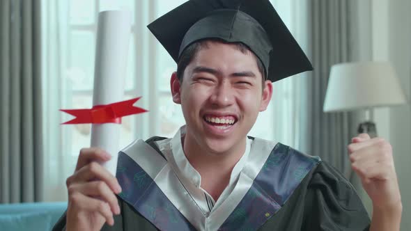 Asian Man Celebrating With University Certificate During An Online Video Call At Home