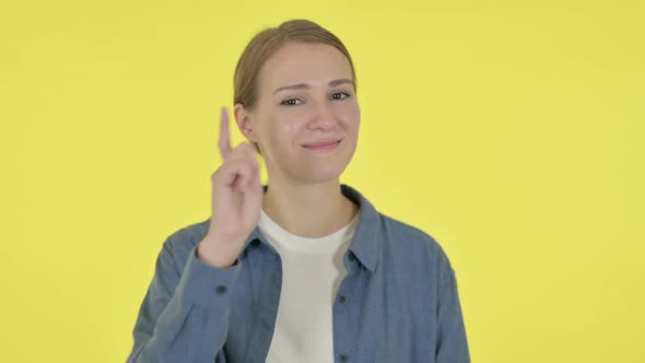 Young Woman Pointing at the Camera on Yellow Background