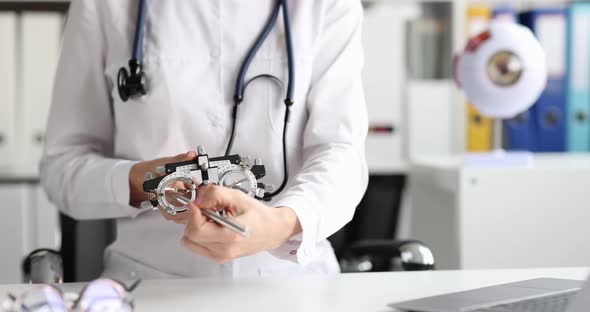 Ophthalmologist Holds Glasses for Selection of Lenses in Frame Closeup