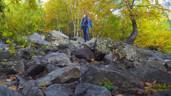 A young beautiful slender woman alone in the mountains.