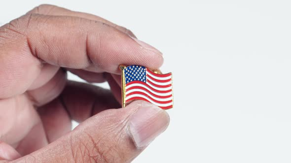 Fingers Hold An American Flag Pin