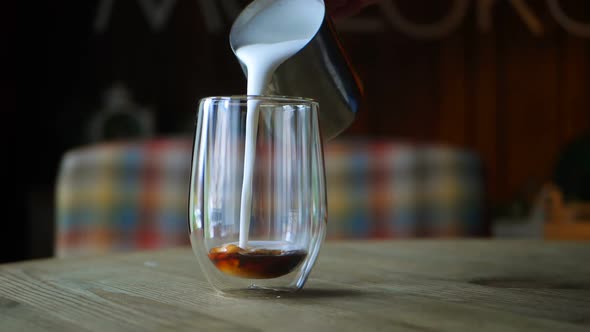 Barista Pours Milk Into a Coffee Glass for Latte