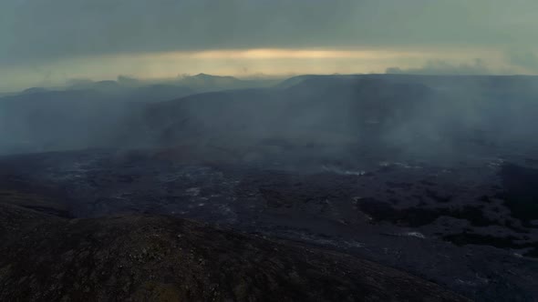 Distant View Of The Magma River Flowing Down The Volcano And Sulfuric Smoke Covering Up The Sky.