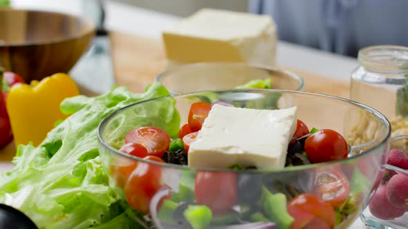 Woman Cooking Vegetable Salad with Feta and Oil