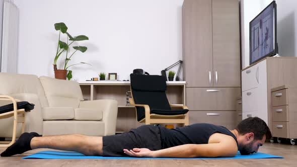 Fit Man on a Blue Mat in His Living Room Does Different Yoga Poses