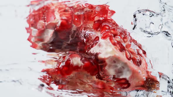 Water splash on open pomegranate. Slow Motion.