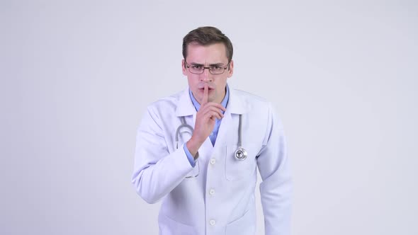 Young Serious Man Doctor with Finger on Lips