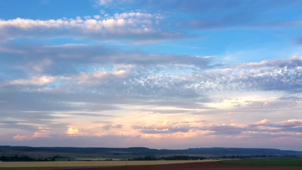 Soothing Time-lapse of sunset pink sky turning to night sky with fast moving clouds over mountains a