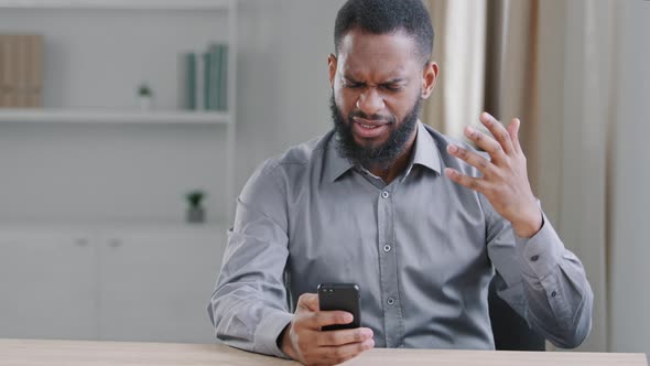 Mad African Businessman Feeling Annoyed Using Smartphone