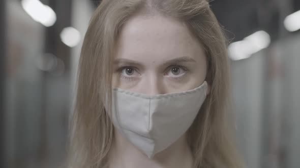 Headshot of Young Confident Caucasian Woman in Covid19 Face Mask Looking at Camera Standing in