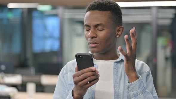 Portrait of African Man Loss on Smartphone