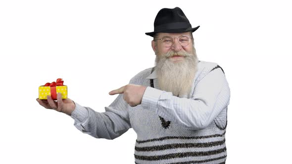 Positive Senior Man Pointing at Gift Box