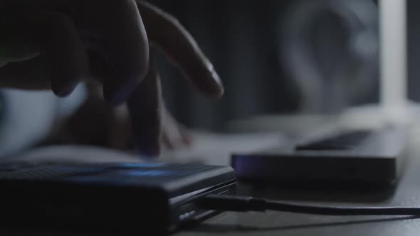 Close up on producer. /musician hand hitting the drum pad and playing a melody riff on MIDI keyboard