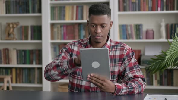 African Man using Tablet while Sitting in Office