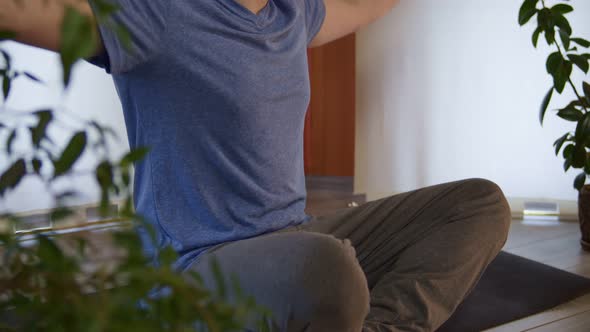 Midsection of Athletic Male in Casual Clothing Sitting in Lotos Pose and Preparing for Meditation