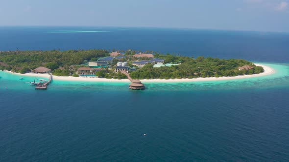 Aerial view on beautiful tropical resort island with water restaurant on Maldives