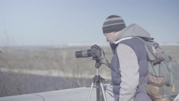 Man Male Cameraman Photographer with a Camera DSLR on a Tripod in the City Shoots Video Photo . Kyiv