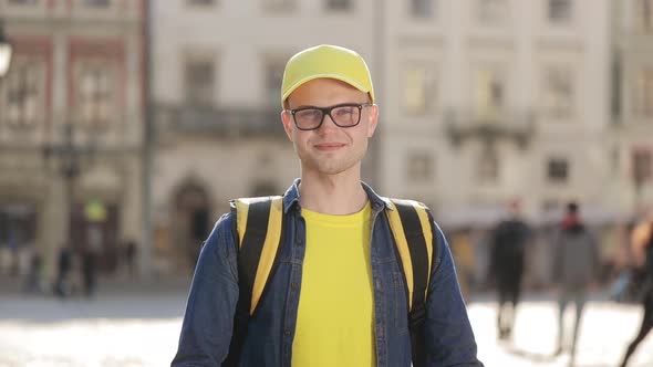 Portrait of a Young Delivery Man Who is Standing and Smiling