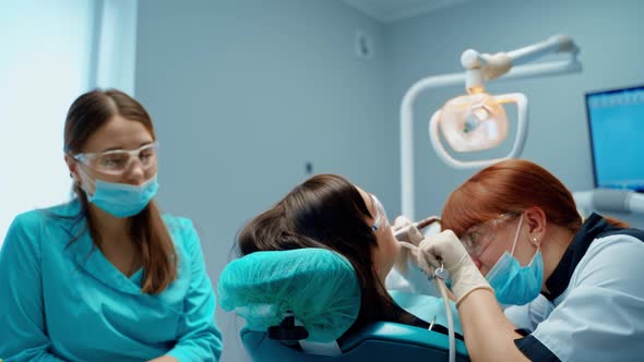 Female client receiving treatment for cavities