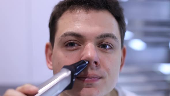 Close Up Face of Man Remove Nose Hair with Help Little Comfy Electric Trimmer