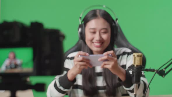 Camera Monitor Recording Woman Looking At Camera While Playing Mobile Phone Game On Green Screen