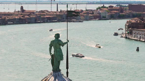 Wide Waterspace with Speedboats Between Rows of Buildings, Male Statue at Front