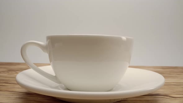 White Cup of Coffee on Wooden Table and White Background