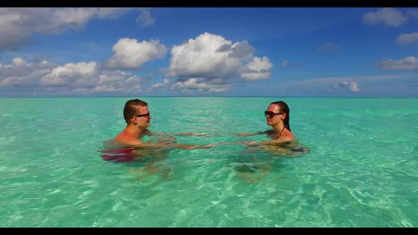 Man and lady posing on marine sea view beach journey by blue water and bright sand background of the