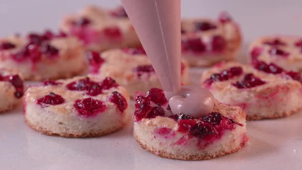 Pastry Chef Squeezes Pink Cream From a Pastry Bag Onto the Mini Cake