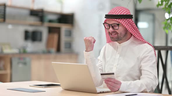 Online Payment Success on Laptop for Young Arab Businessman in Office 