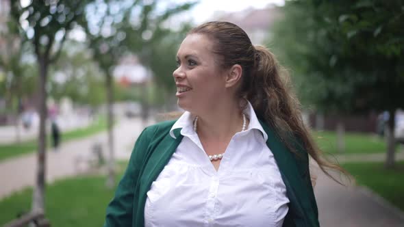 Front View Tracking Shot Positive Confident Obese Caucasian Woman Walking on City Street in Slow