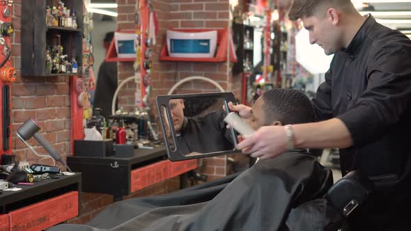 The Hairdresser Shows the Client the Result of the Haircut and Shave in the Hand Mirror