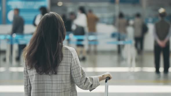 Back View of Young Businesslady in a Middle of Airport Terminal