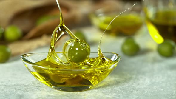 Super Slow Motion Shot of Fresh Olive Splashing Into Olive Oil at 1000 Fps