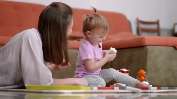 Little Baby Girl and Mommy Playing Color Wooden Toys at Home Sitting on Floor Mother and Daughter