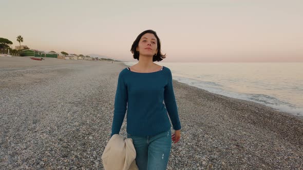 Beautiful Girl Walks at the Beach by the Ocean