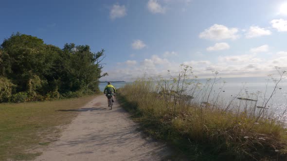 POV View of Two Cyclist Rides on a Gravel Bike Path Next to the Ocean in the North of France Region