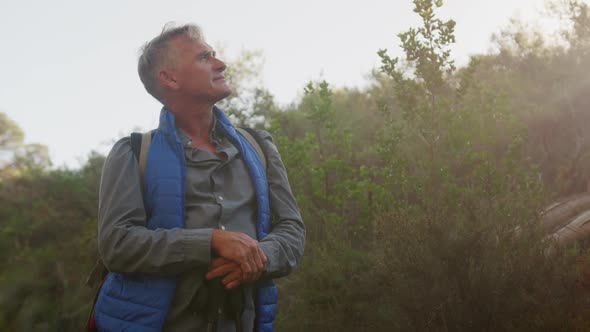 Active senior standing in forest