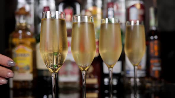 Closeup of a Woman Taking a Glass of Cold Champagne in a Bar