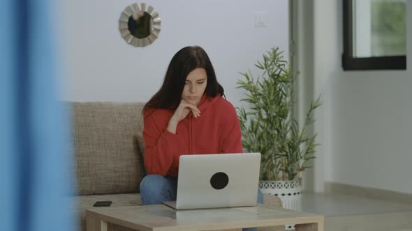 Thoughtful concerned brunette freelancer woman working in home office typing letter