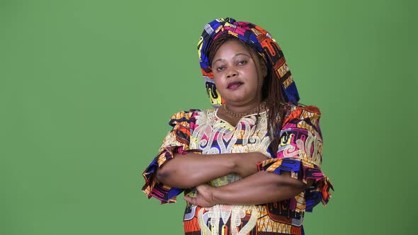 Overweight Beautiful African Woman Wearing Traditional Clothing Against Green Background