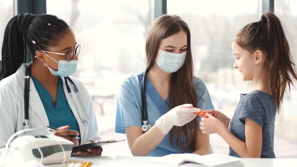 Two Female Doctors and Girl on Check Up