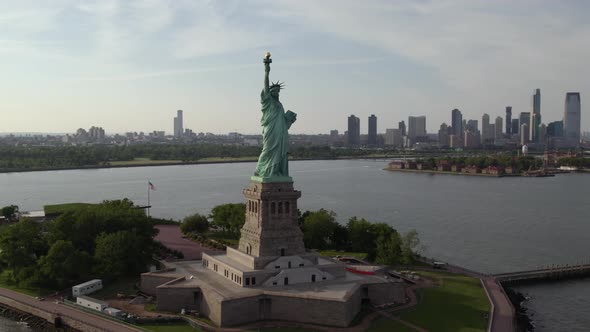 Aerial view around the Statue of Liberty, in sunny New York, USA - orbit, drone shot