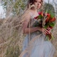 A Young Woman Dressed in a Gray Wedding Dress. She Has Flowers in Her Hand and Is in the Park - VideoHive Item for Sale