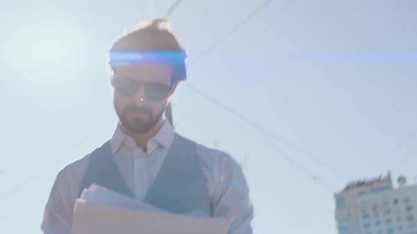 Manager Looks at Documents Walking Along the Street