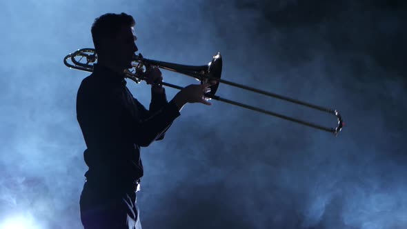 Silhouette Professional Musician Man Playing on Trumpet. Smoky Isolated Studio