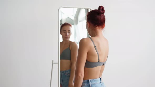 Attractive Happy Woman Looks in Mirror Choosing What Wear on White Background