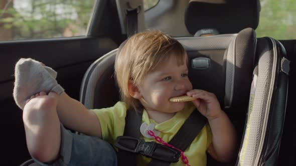 The Child Eats Cookies While Traveling in the Car